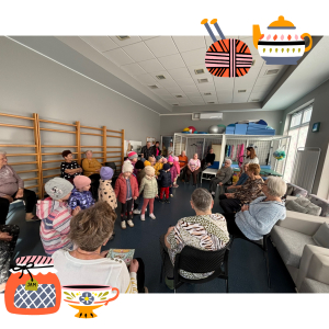 Zdjęcie przedstawia dzieci z grupy Żabki podczas wizyty u Seniorów.