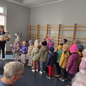 Zdjęcie przedstawia dzieci z grupy Żabki podczas wizyty u Seniorów.